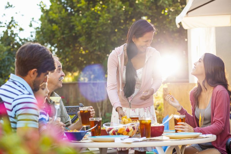 hispanic family laughing and eating together