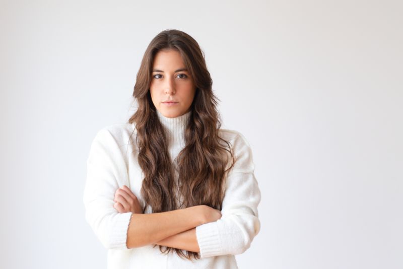 serious hispanic woman standing with arms crossed