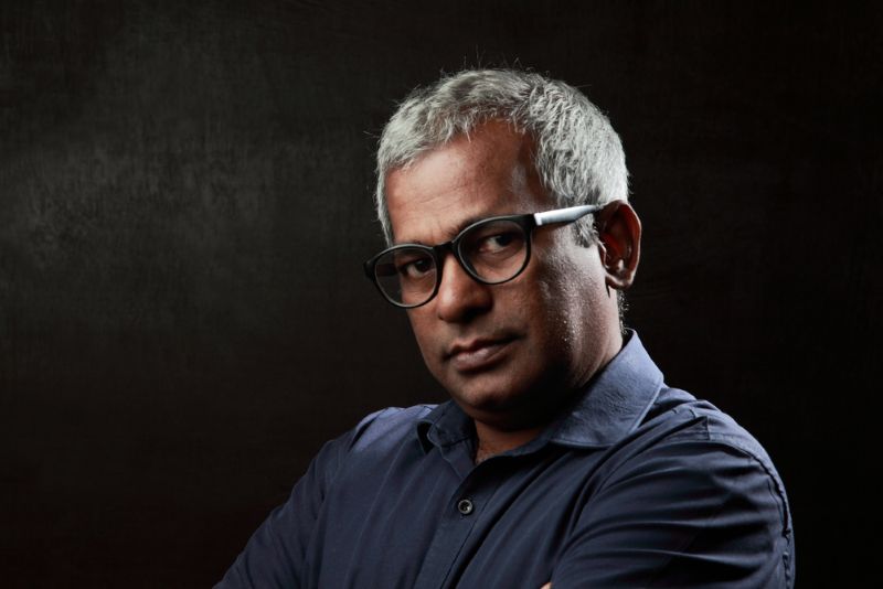 older immigrant man with glasses and serious expression
