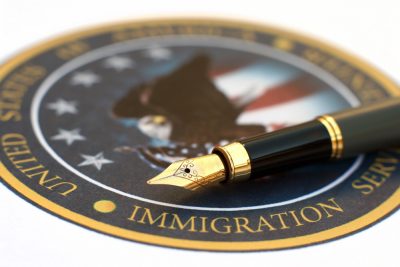 pen over immigration services seal