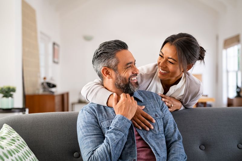 Immigrant couple smiling in their living room